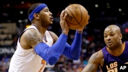 Carmelo Anthony de New York Knicks tire un panier contre Phoenix devant Suns de l' P.J. Tucker qui défend la première moitié du cours d'un match de basket NBA , le mercredi 9 Mars , 2016, à Phoenix . (AP Photo / Matt York )