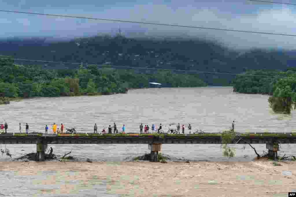 People watch the Humuya river flooding due to heavy rains caused by Eta Hurricane, in Santa Rita, Yoro department, 240 km northern Tegucigalpa, Nicaragua, Nov. 3, 2020.