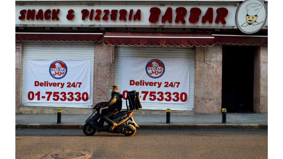 A food delivery scooter passes Barbar Restaurant that now offers food for delivery only, after most of the shops and restaurants closed, Beirut, March 21, 2020.