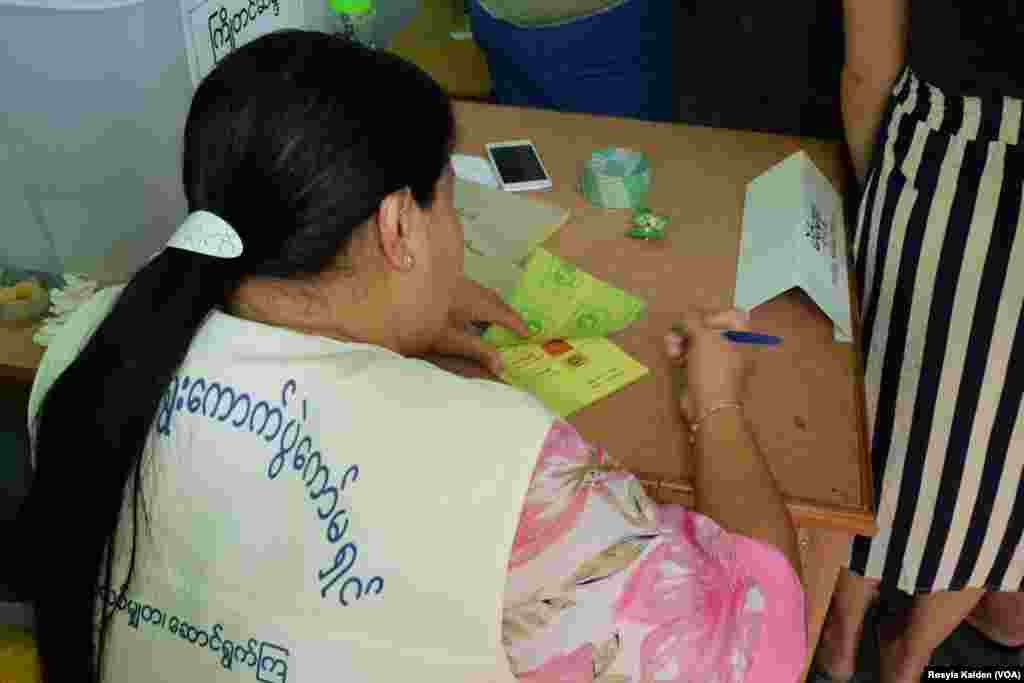 Seorang petugas di TPS memeriksa kertas suara, Yangon, 8 November 2015.