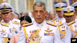 FILE - Thai King Maha Vajiralongkorn, center, holds a candle light during a ceremony at Emerald Buddha temple, in Bangkok, Thailand, May 29, 2018.