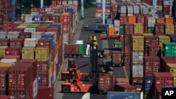 FILE - Containers are moved at the Port of New York and New Jersey in Elizabeth, New Jersey, June 30, 2021.