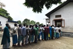 FILE - People stand in line to check for their names on the final list of the National Register of Citizens (NRC), in an office in Pavakati village of Morigoan district, in India's northeastern state of Assam, Aug. 31, 2019.