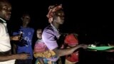 FILE - South Sudanese refugees receive food after being transported from the border of South Sudan and the Democratic Republic of the Congo (DRC) to a refugee settlement site in Aru, DRC, May 10, 2019. 