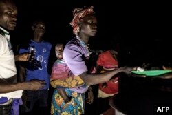 FILE - South Sudanese refugees receive food after being transported from the border of South Sudan and the Democratic Republic of the Congo (DRC) to a refugee settlement site in Aru, DRC, May 10, 2019.