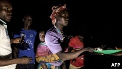 FILE - South Sudanese refugees receive food after being transported from the border of South Sudan and the Democratic Republic of the Congo to a refugee settlement site in Aru, DRC, May 10, 2019. 