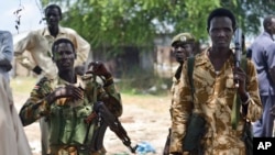 Des soldats du gouvernement sud-soudanais patrouillent dans le village Bentui, Soudan du Sud, 24 juin 2015.