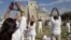 People raise their arms towards the sun while standing in front of the Kukulcan pyramid in Chichen Itza March 20, 2011.