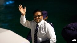 Former Maldives vice president Ahmed Adeeb waves to the media before he boards a police speed boat in Maldives, June 10, 2015.