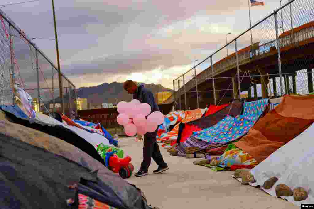 Jeahn Carlos Mayorga, un migrante de Venezuela que no ha cruzado a EEUU debido a las nuevas políticas de inmigración, lleva globos para niños de Venezuela en un campamento cerca del puente fronterizo internacional Paso del Norte, en Ciudad Juárez, México, el 24 de octubre de 2022. REUTERS/José Luis González