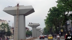 FILE - Motorists pass by a stretch of a metro railway project being constructed in Hanoi, Vietnam, April 7, 2013.