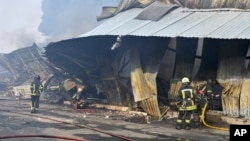 FILE - Firefighters put out the fire following a Russian drone attack that hit warehouses in Odesa, Ukraine, March 11, 2025.