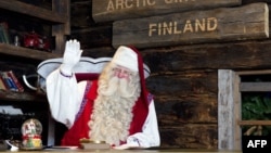 FILE - Santa Claus waves to his visitors as they leave his office in Santa Park near Rovaniemi, Finnish Lapland, on Dec. 14, 2011.