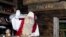 FILE - Santa Claus waves to his visitors as they leave his office in Santa Park near Rovaniemi, Finnish Lapland, on Dec. 14, 2011.
