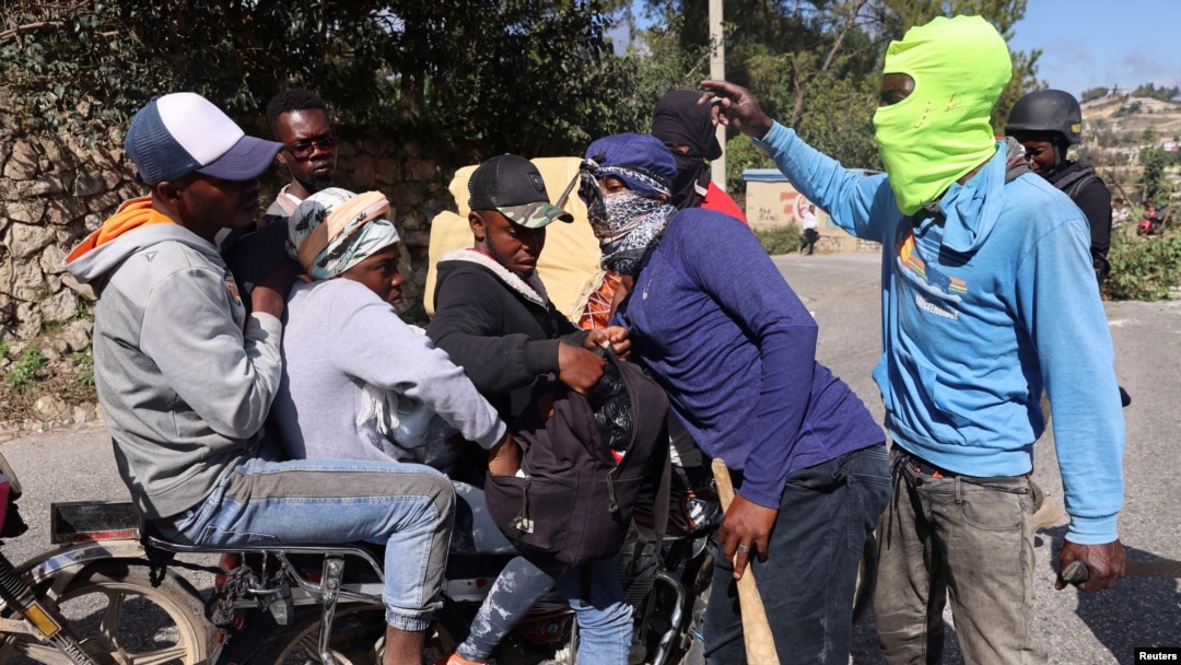 Hooded residents stop people at a checkpoint to check if they carry weapons following days of gang violence, in the Kenscoff neighborhood, in Port-au-Prince, Haiti, Jan. 29, 2025. 