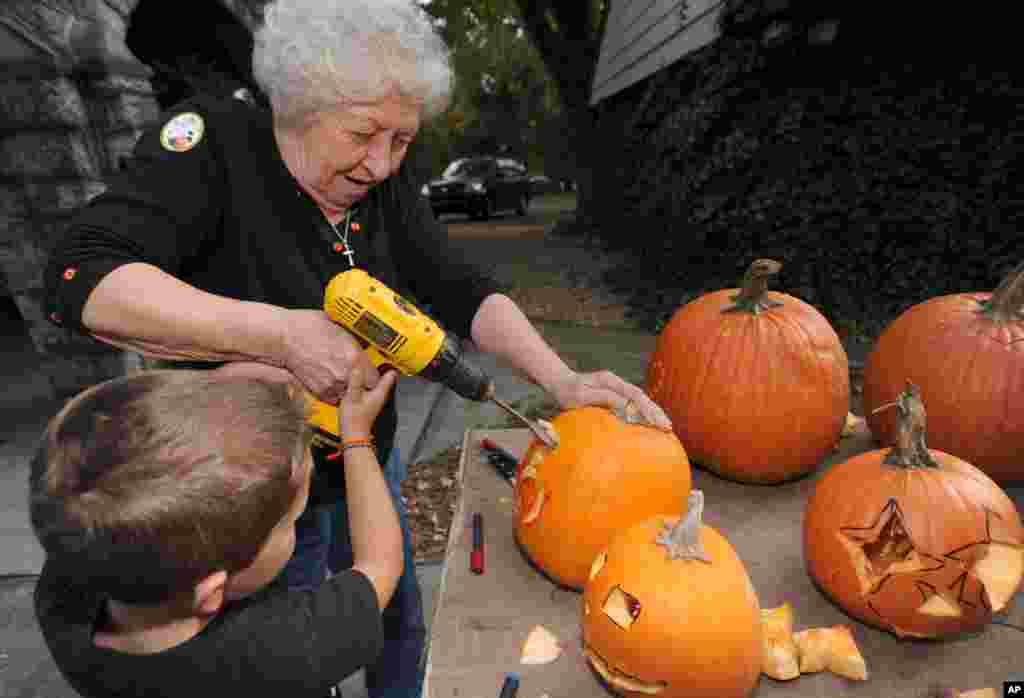 Betty Dillow membantu cucunya Judge mengukir labu di Bristol, negara bagian Virginia, AS.(AP/Earl Neikirk)