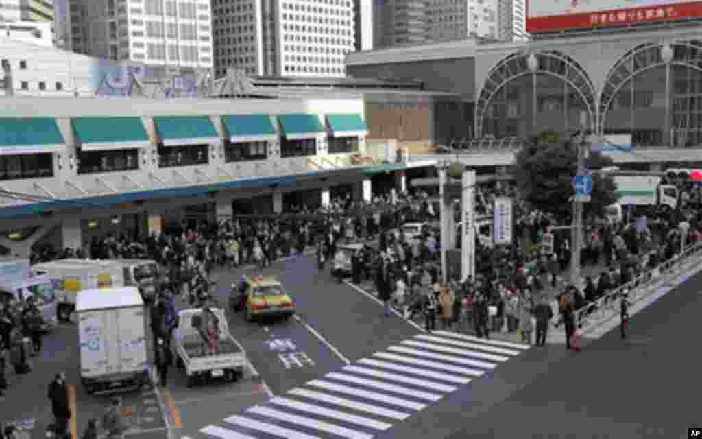 Train passengers wait outside Tokyo's Shinagawa station after a magnitude 8.9 earthquake slammed Japan's eastern coast, March 11, 2011 - (AP)