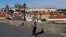 A woman wearing a face mask walks across the medieval Charles Bridge, as the Czech government shut sports, culture and social venues for two weeks to slow down the spread of the coronavirus disease (COVID-19), in Prague, Czech Republic, October 12.
