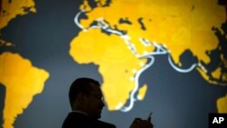 FILE - A visitor uses his phone during the Mobile World Congress wireless show, Feb. 26, 2018. Chile, New Zealand and Singapore have formed a new grouping known as the Digital Economy Partnership Agreement, or DEPA, which focuses on digital issues. 