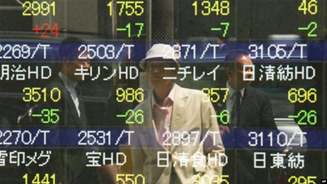 Seorang pria mengamati bergolaknya bursa saham di papan sekuritas di Tokyo (7/5). Saham-saham Asia turun hari Minggu seiring kekhawatiran krisis ekonomi di Eropa pasca pemilu Yunani dan Perancis.