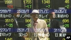 Seorang pria mengamati bergolaknya bursa saham di papan sekuritas di Tokyo (7/5). Saham-saham Asia turun hari Minggu seiring kekhawatiran krisis ekonomi di Eropa pasca pemilu Yunani dan Perancis.