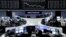 FILE - Traders work at their desks in front of the German share price index, DAX board, at the stock exchange in Frankfurt, Germany, Feb. 16, 2016. 