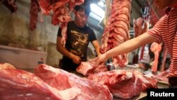 A customer chooses a cut of beef at a meat market in Beijing May 31, 2013. With more money in their pockets, millions of Chinese are switching to beef, driving imports to record levels and sending local meat firms abroad to scout for potential acquisition targets among beef farmers and processors. 