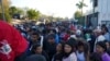 Migrantes venezolanos hacen fila para recibir un boleto para una fecha de solicitud de asilo en Estados Unidos, en Matamoros, México, el jueves 22 de diciembre de 2022.
