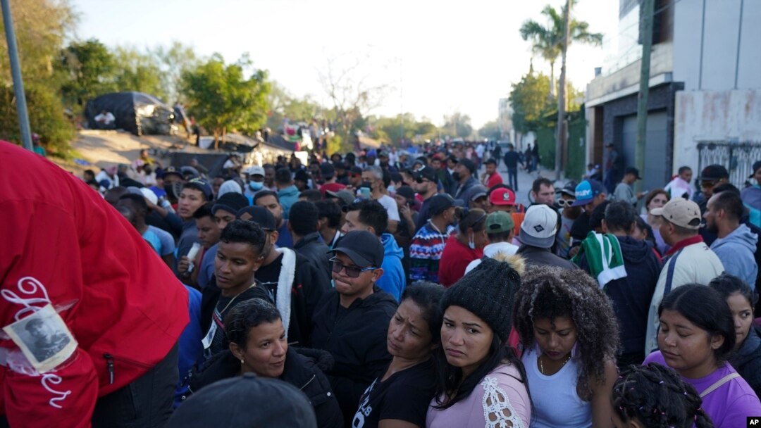 Migrantes venezolanos hacen fila para recibir un boleto para una fecha de solicitud de asilo en Estados Unidos, en Matamoros, México, el jueves 22 de diciembre de 2022.