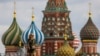 FILE - A woman walks in Red Square with the domes of St. Basil's Cathedral in the background in Moscow, May 16, 2024.