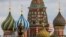 FILE - A woman walks in Red Square with the domes of St. Basil's Cathedral in the background in Moscow, May 16, 2024.