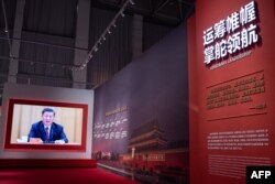 FILE - A video of China's President Xi Jinping plays at an exhibition about China’s fight against COVID-19 at a convention center that was previously a makeshift hospital for coronavirus patients, in Wuhan, Jan. 15, 2021.