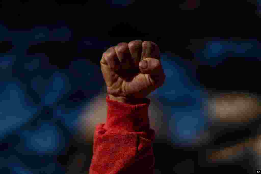 A protester clenches his fist as he sings the worker&#39;s hymn &quot;The Internationale&quot; during a half-day strike to protest government proposed reforms titled La Ley de Urgente, or The Urgent Law, in Montevideo, Uruguay.