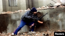 FILE - A Chechen fighter moves into position next to the Presidential Palace in central Grozny during heavy fighting, Jan. 10, 1995.