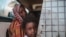 FILE - In this file picture taken Tuesday, April 14, 2015, a Sudanese girl looks out of the window while waiting with her mother in a public bus in Izba, an impoverished neighborhood on the outskirts of Khartoum, Sudan. Forty percent of children…