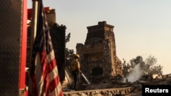 Seorang petugas pemadam kebakaran bekerja di lokasi gedung yang terbakar, setelah Kebakaran Eaton, di Altadena, California, AS, 10 Januari 2025. (Foto: REUTERS/Maria Alejandra Cardona)