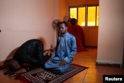 FILE - Barry prays with his friend Abd el-Rahman Al Zuhr, at his new home in El Marg district in the east of Cairo, Egypt, September 23, 2023.