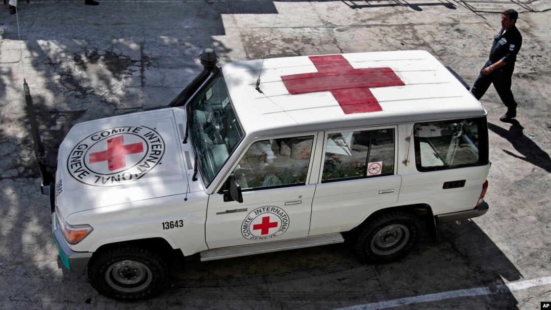 FILE - An Afghan policeman walks past a Red Cross vehicle in Jalalabad, east of Kabul, Afghanistan, May 30, 2013. Suspected Islamist militants reportedly killed six ICRC aid workers and abducted two others Wednesday after ambushing their convoy in northern Jowzjan province. 