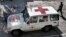 FILE - An Afghan policeman walks past a Red Cross vehicle in Jalalabad, east of Kabul, Afghanistan, May 30, 2013. Suspected Islamist militants reportedly killed six ICRC aid workers and abducted two others Wednesday after ambushing their convoy in northern Jowzjan province. 