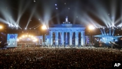 FILE - Balloons of the art installation "Lichtgrenze 2014" fly away in front of Brandenburg Gate during the central event commemorating the fall of the Wall in Berlin, Germany, Nov. 9, 2014. 