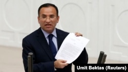 FILE - Turkish Justice Minister Bekir Bozdag addresses the Turkish Parliament during a debate in Ankara, Turkey, March 19, 2014. On Wednesday, Bozdag called Norway reportedly granting political asylum to Turkish military officers allegedly involved in last year's failed coup in Turkey "not an acceptable situation."