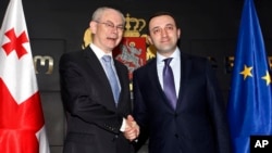 FILE - European Council President Herman Van Rompuy and Georgian Prime Minister Irakly Garibashvili (R) shake hands during their meeting in Tbilisi, Georgia, May 14, 2014.