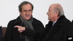 Michel Plaitini, président suspendu de l'UEFA, à gauche, discute avec Sepp Blatter, président démissionnaire de la FIFA, également suspendu.