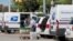 FILE - United States Postal Service workers load mail into delivery trucks outside a post office in Royal Oak, Michigan, Aug. 22, 2020. 
