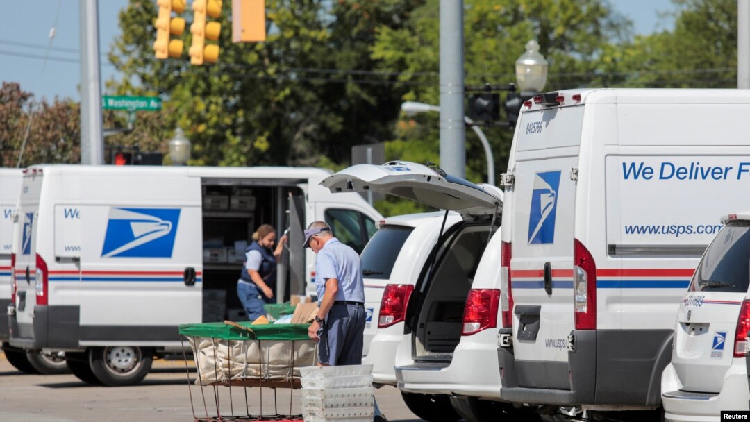 Petugas Kantor Pos As (USPS) tampak tengah memasukan paket ke dalam truk pengiriman di luar sebuah kantor pos di Royal Oak, Michigan, pada 22 Agustus 2020. (Foto: Reuters/Rebecca Cook)