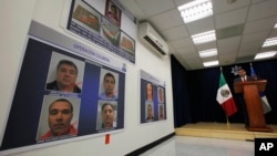 Ramon Pequeno, head of Mexico's federal police anti-narcotics division, speaks at a press conference next to photos of nine arrested suspects in Mexico City, March 23, 2011. 