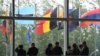 FILE - Workers stand near flags of countries participating in the Belt and Road Forum at one of the venues of the forum in Beijing, April 27, 2019. 