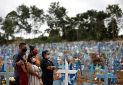 Relatives are seen during a mass burial of people who passed away due to the coronavirus disease, at the Parque Taruma cemetery in Manaus, Brazil, May 26, 2020.