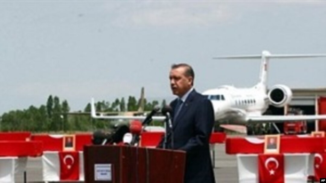 Turkish Prime Minister Recep Tayyip Erdogan delivers a speech near soldiers 'coffins at Van airport, eastern Turkey, 19 Jun 2010
