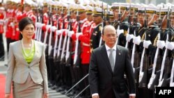 Burma President Thein Sein (R) and Thai Prime Minister Yingluck Shinawatra (L) review the honor guard during a welcoming ceremony in Bangkok, July 23, 2012.